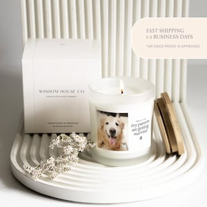 May include: A burning candle in a glass jar with a wooden lid, displaying a photo of a golden retriever and the text "my parents are getting married." A white box with the text "WISDOM HOUSE CO" is behind the candle.