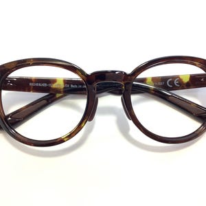 May include: Tortoise shell round eyeglasses with clear lenses. The frame has the text "MAUI JIM-1534 Made in Japan" on the left arm and "7213567 CE" on the right arm.