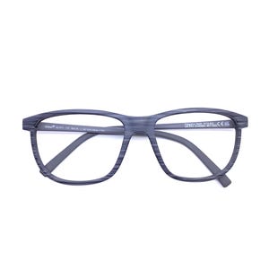May include: Eyeglasses with a dark grey, wood-grain textured frame. The rectangular lenses are clear, and the temples are a solid dark grey. The glasses are set against a white background.