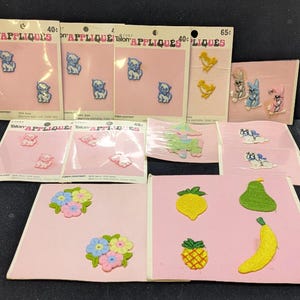Może przedstawiać: Kolekcja vintage naszywek z aplikacjami Talon na różowych kartach. Naszywki przedstawiają różne wzory, w tym kotki, kurczaki, króliki, kwiaty i owoce. Karty mają napis "APPLIQUES" i metki z cenami.