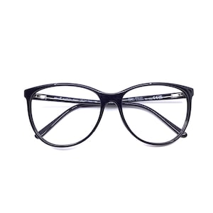 May include: Black eyeglasses with a rounded, slightly cat-eye shape. The frames are a glossy black, and the lenses are clear. The temples are thin and black, and the glasses are set against a white background.