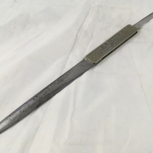 Może przedstawiać: Srebrny otwieracz do listów z ostrzem i uchwytem, na którym widnieje napis "John Evans & Co.  Evans Lea.  Sheffield."