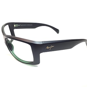May include: Black rectangular eyeglasses with a silver accent on the top frame. The lenses are green. The brand name "Maui Jim" is in gold lettering on the temple. The glasses have a modern, sleek design.