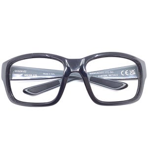 May include: Black rectangular eyeglasses with a thick frame. The glasses have a dark gray interior and temples. The text "MJ604-02" and "60018-125" is visible on the left arm. The text "MANGROVES STG-BG" and "6145984; 9671622" is visible on the right arm.