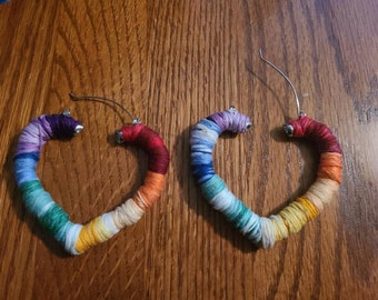 Heart shaped earrings wrapped in rainbow color thread