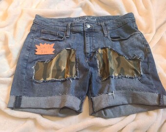 Size youth 12 Cut Off Shorts With Camo sewed into the front of the shorts.