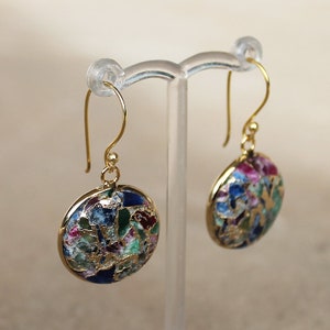 May include: A pair of gold earrings with round, colourful, mosaic-like designs. The earrings have a gold hook fastening.