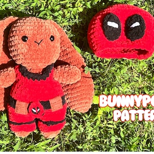 Puede incluir: Un conejito amigurumi tejido a crochet con un disfraz de Deadpool rojo y negro. El conejito tiene pelaje marrón y ojos negros. El disfraz tiene un cinturón negro y una máscara roja con ojos blancos. El texto "BUNNYPOOL PATTERN" es visible en la imagen.