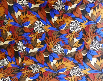 May include: A colorful fabric with a repeating pattern of blue flowers and white zebras. The background is a cream color with brown and orange accents.