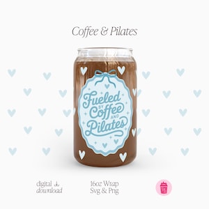 May include: A clear glass can-shaped cup filled with a brown liquid, possibly coffee. The cup features a light blue label with the text "Fueled by Coffee and Pilates." White heart shapes are scattered around the cup. The words "Coffee & Pilates" are at the top.