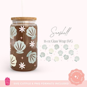Puede incluir: Un vaso transparente en forma de lata con tapa de madera y pajita, decorado con gráficos de conchas marinas azul claro y flores blancas. Se muestra el texto "Seashell 16 oz Glass Wrap SVG". El vaso está lleno de un líquido marrón.