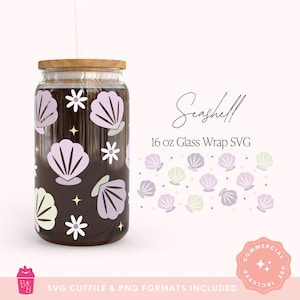 May include: A glass wrap design for a 16 oz glass. The design features seashell graphics in lavender and light green, along with white flowers and stars. The glass has a wooden lid and a straw.