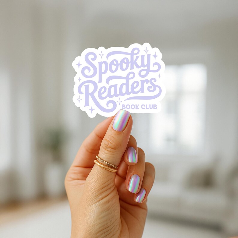 May include: A die-cut sticker featuring the text Spooky Readers BOOK CLUB in a light purple cursive font, accented with small four-pointed star icons. The sticker has a white border and a matte finish, displaying a whimsical design for book lovers.