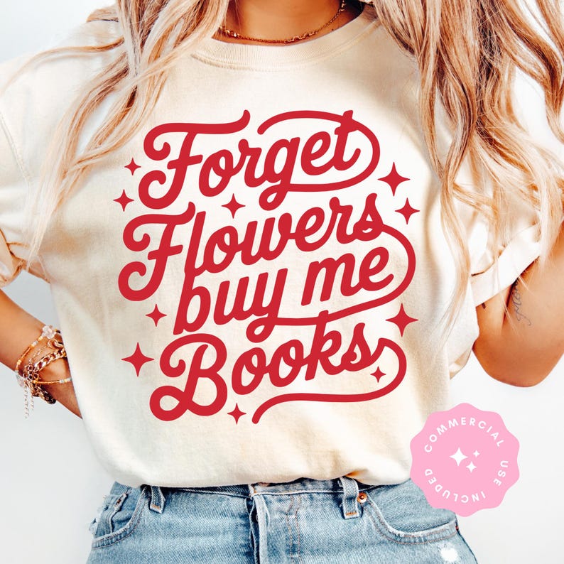 Puede incluir: Camiseta color crema con el texto rojo "Forget Flowers buy me Books" en escritura cursiva, con detalles de estrellas. La camiseta se lleva con vaqueros azules.