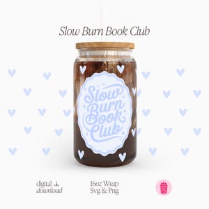 Może przedstawiać: Przezroczysty szklany kubek z drewnianą pokrywką i słomką. Kubek ma jasno-niebieską i białą etykietę z napisem "Slow Burn Book Club". Szkło zawiera ciemny płyn. Projekt zawiera małe białe serca.