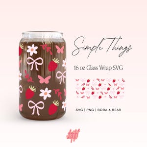 May include: A 16 ounce glass wrap SVG design featuring a pink and red pattern with strawberries, butterflies, bows, and flowers. The design is shown on a clear glass tumbler. The text "Simple Things" is written in cursive above the tumbler. The text "SVG | PNG | BOBA & BEAR" is written below the tumbler.