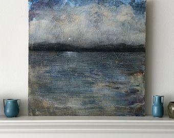 Op de afbeelding: Een schilderij van een zeegezicht met een bewolkte lucht en een kalme, blauwe zee. De horizon is in de verte zichtbaar en het schilderij heeft een gedempt kleurenpalet.