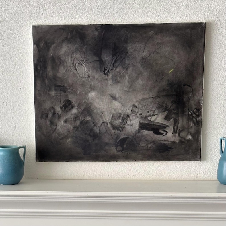 May include: A rectangular canvas painting featuring abstract charcoal and black ink marks on a light background. The composition displays layered, gestural strokes, smudges, and thin lines that create a sense of depth and movement across the surface.