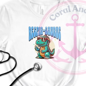 May include: White t-shirt with a cartoon dinosaur wearing sunglasses and holding a bottle of hand sanitizer. The text "Respir-saurus" is above the dinosaur.