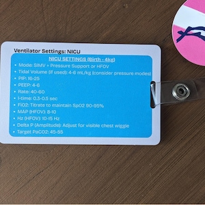 May include: A white and blue card with medical ventilator settings for NICU patients. The card includes settings for mode, tidal volume, PIP, PEEP, rate, I-time, FiO2, MAP, Hz, Delta P, and target PaCO2. A pink and white circular tag with a diver silhouette is attached.