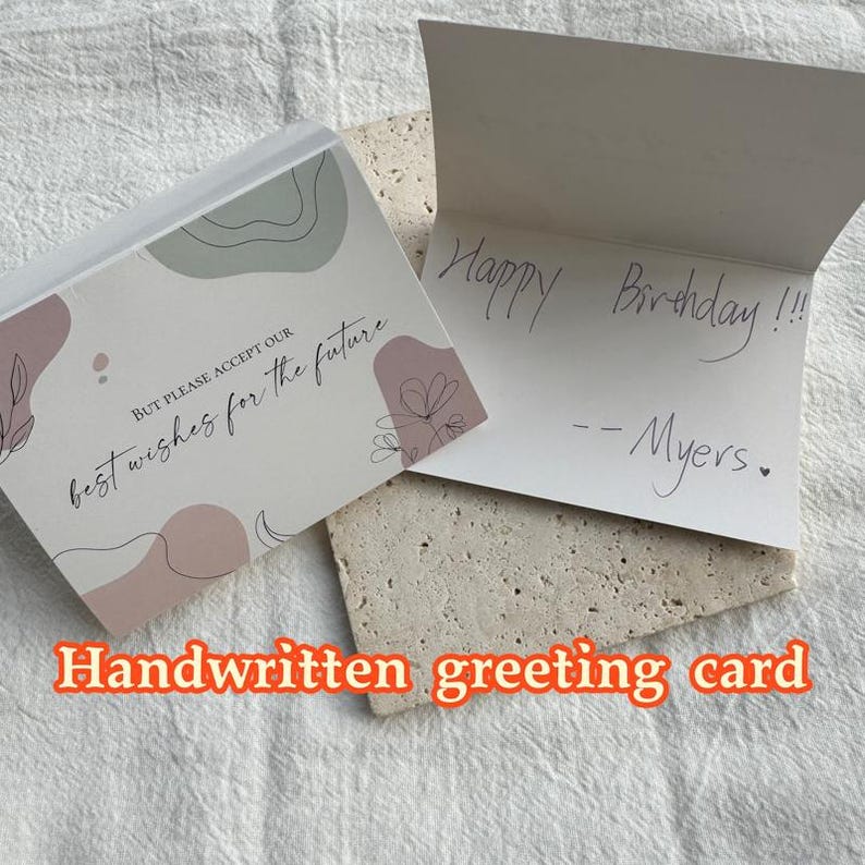 May include: A handwritten greeting card with a pink and green abstract design. The card reads "BUT PLEASE ACCEPT OUR best wishes for the future". The inside of the card has the message "Happy Birthday!!! --Myers."