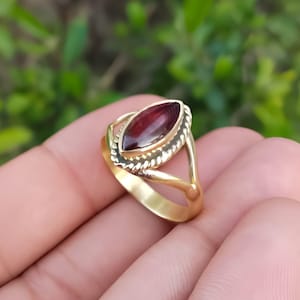Peut inclure: Bague dorée ornée d'une pierre de couleur marron en forme de marquise. La bague présente un motif torsadé autour de la pierre et un anneau fendu. Le texte "Silver Jewellery Exports" est visible en arrière-plan.