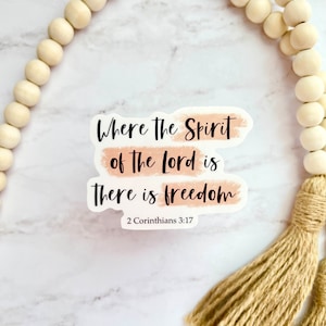May include: A white sticker with a peach-colored background and black text that reads "Where the Spirit of the Lord is there is freedom" with the scripture reference "2 Corinthians 3:17" below the text.