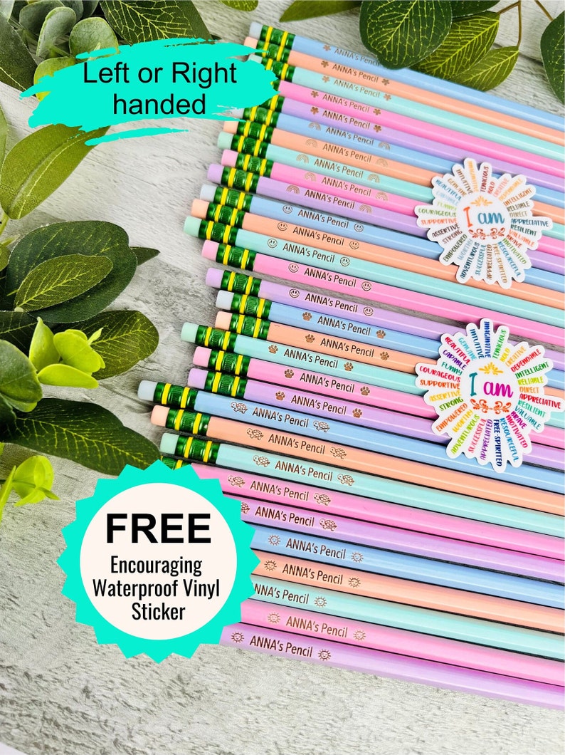 Puede incluir: Una colecci&oacute;n de l&aacute;pices de colores pastel con gomas verdes, cada uno con la etiqueta "ANNA's Pencil" con varios iconos peque&ntilde;os. Tambi&eacute;n son visibles dos pegatinas con afirmaciones positivas. La imagen incluye el texto "Left or Right handed" y "FREE Encouraging Waterproof Vinyl Sticker."