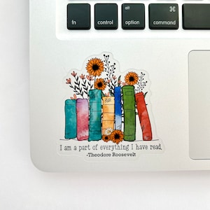 May include: A sticker with a quote by Theodore Roosevelt, "I am a part of everything I have read." The quote is surrounded by a stack of colorful books with flowers and sunflowers.