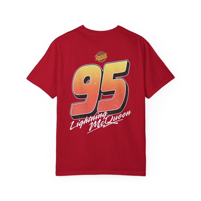 Pu&ograve; includere: Maglietta rossa con un grande numero 95 giallo e arancione sul retro. Il testo "Lightning McQueen" &egrave; scritto in bianco sotto il numero.