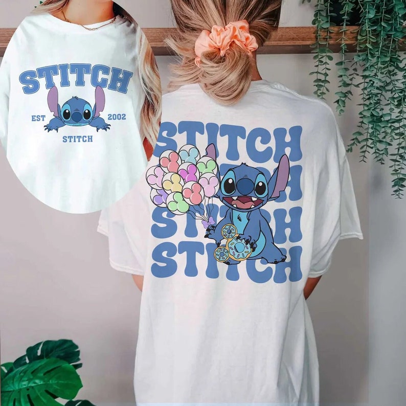 May include: White t-shirt with a blue Stitch character holding balloons on the back. The front of the shirt has the text "Stitch Est 2002" with a smaller Stitch character underneath.