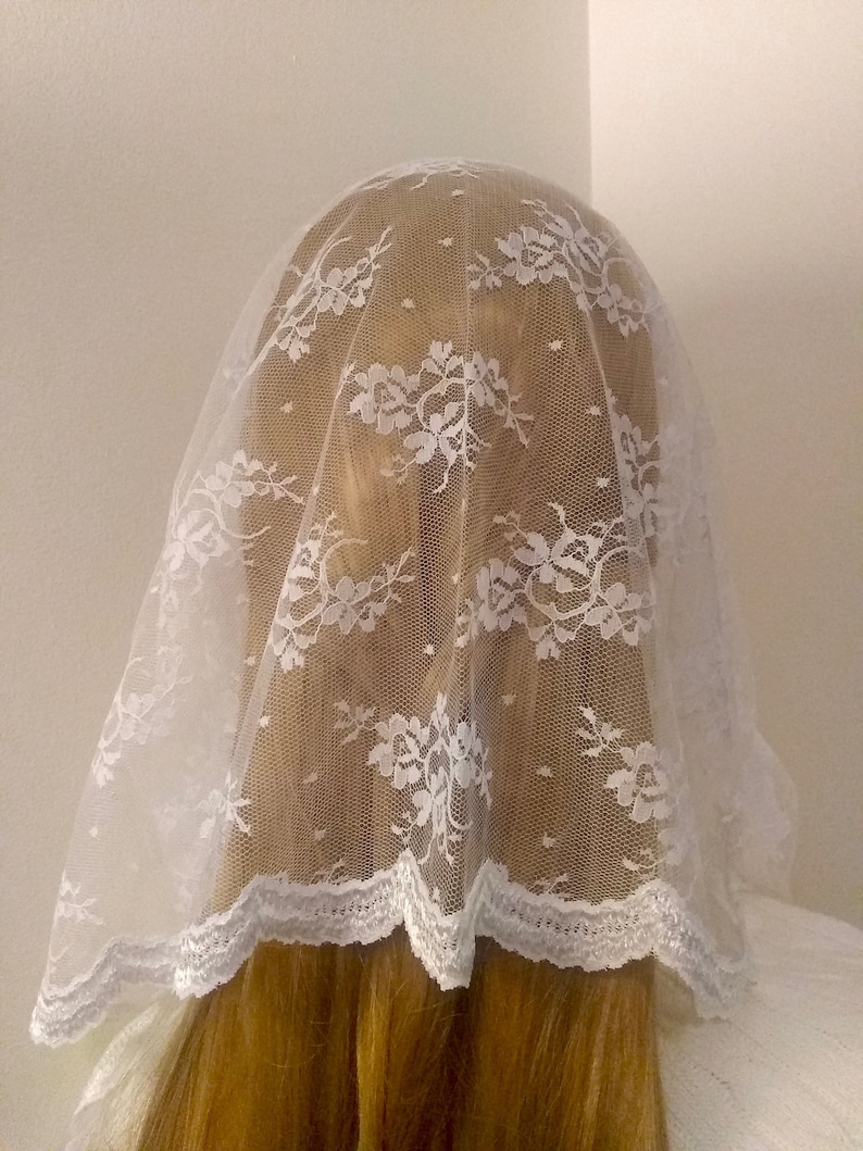 May include: White lace veil with a scalloped edge. The veil is made of delicate lace and is perfect for a special occasion.