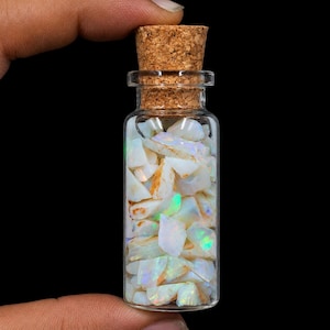 Fragmentos de ópalo australiano natural en bruto de 138,00 quilates en botella de vidrio. Cristal de ópalo.