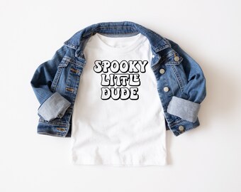 May include: White t-shirt with the text "SPOOKY LITTLE DUDE" in black outlined letters.
