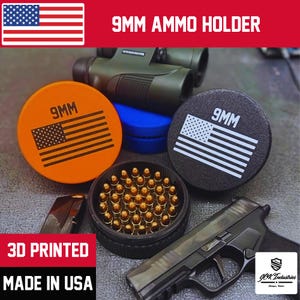 May include: An orange and black 9mm ammo holder with an American flag design. The image also shows a black handgun, a container of bullets, and the text "3D PRINTED MADE IN USA".