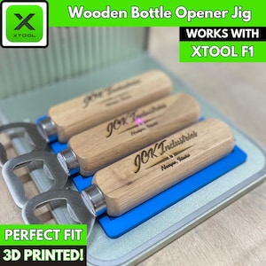 May include: Three wooden bottle openers with a metal bottle opener attached to each. The openers are engraved with the text "JOK Industries" and "Nampa, Idaho". The openers are on a blue mat and a silver surface. The text "WORKS WITH XTOOL F1" is in the upper right corner of the image. The text "PERFECT FIT 3D PRINTED!" is in the lower left corner of the image.