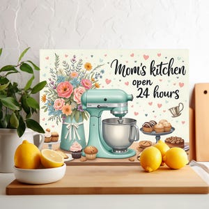 May include: A kitchen-themed chopping board with a turquoise stand mixer, a bouquet of flowers, and cupcakes. The text "Mom's kitchen open 24 hours" is printed on the board.