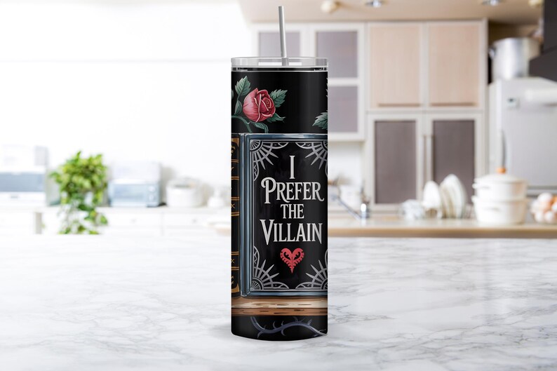 Puede incluir: Un vaso de acero inoxidable negro con un dise&ntilde;o de libro con una rosa y el texto "I Prefer the Villain" con un coraz&oacute;n.