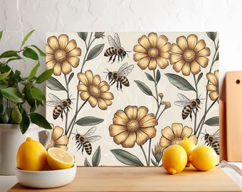 Op de afbeelding: Een rechthoekige decoratieve snijplank met een herhalend patroon van gele bloemen en bijen op een crèmekleurige achtergrond. De bloemen hebben gedetailleerde bloemblaadjes en de bijen zijn in vlucht. De plank is van licht materiaal.