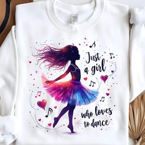 May include: White sweatshirt with a graphic of a girl dancing with a galaxy-inspired skirt and the text "Just a girl who loves to dance".