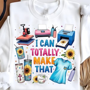 May include: White sweatshirt with a graphic design featuring a heat press, a printer, and tumblers. The text reads "I can totally make that".