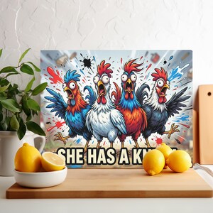 May include: A rectangular canvas print featuring four cartoon chickens with wide eyes and open beaks. The chickens are in various colors, including blue, red, white, and black. The text "SHE HAS A K" is at the bottom. Lemons are in the foreground.