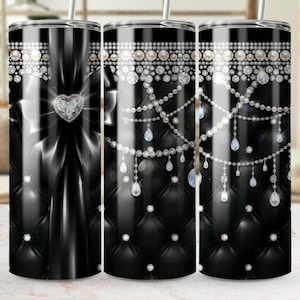 May include: A black tumbler with a diamond and pearl design. The tumbler features a black quilted pattern, a large bow with a heart-shaped diamond, and strings of pearls and diamonds. The design is elegant and luxurious.