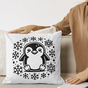 Puede incluir: Almohada blanca con una ilustración en blanco y negro de un pingüino rodeado de copos de nieve.