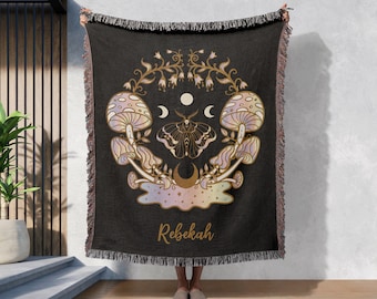 May include: Black woven throw blanket with a colorful, iridescent design featuring mushrooms, a moth, and crescent moons. The text "Rebekah" is printed in gold at the bottom.