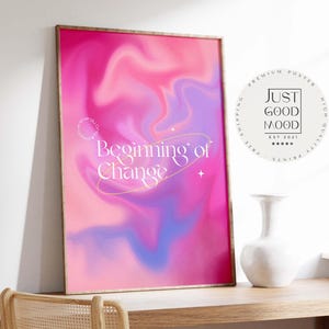Puede incluir: Un póster enmarcado con un vibrante diseño abstracto rosa, morado y azul. Las palabras "Beginning of Change" están escritas en una elegante escritura. Es visible una pegatina circular con el texto "JUST GOOD MOOD". Un jarrón blanco está sobre una superficie de madera.