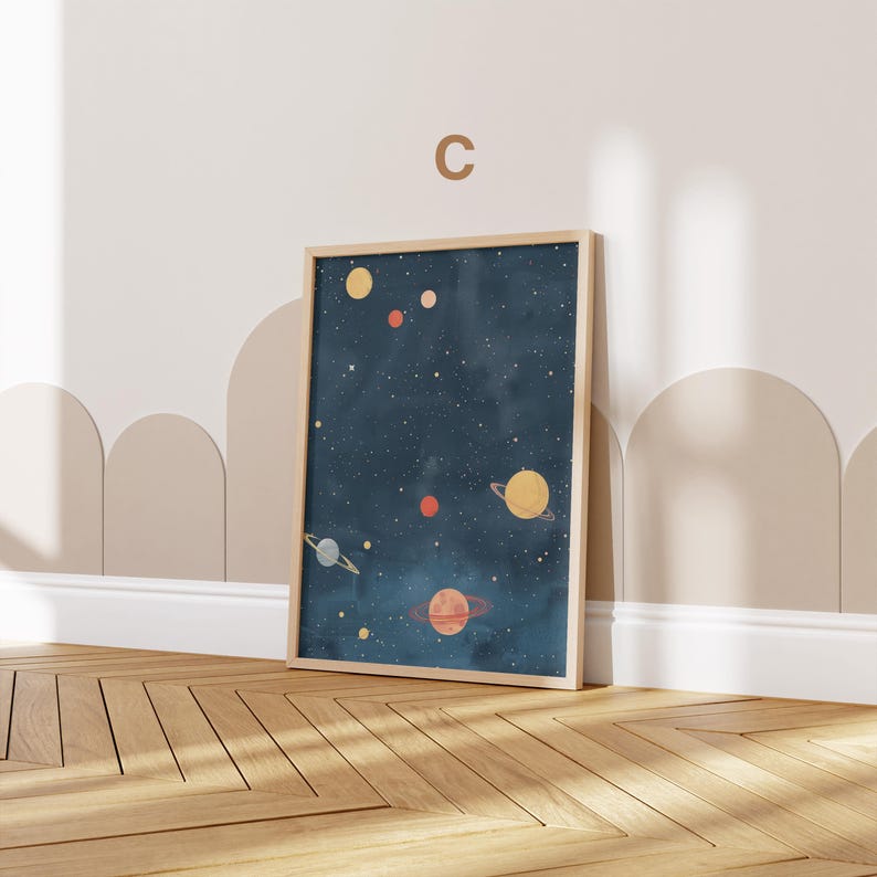 May include: A framed print of a dark blue night sky with stars and planets in various colours, including yellow, orange, and red. The print is in a light wood frame.