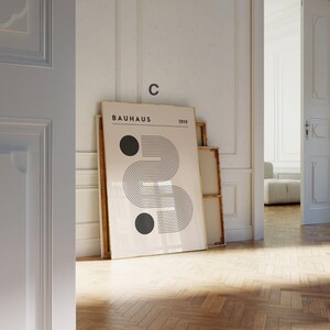 Puede incluir: Una impresi&oacute;n enmarcada con un dise&ntilde;o geom&eacute;trico en blanco y negro. La impresi&oacute;n tiene el texto "BAHAUS 1919" en la parte superior y una gran "C" en la esquina superior derecha.