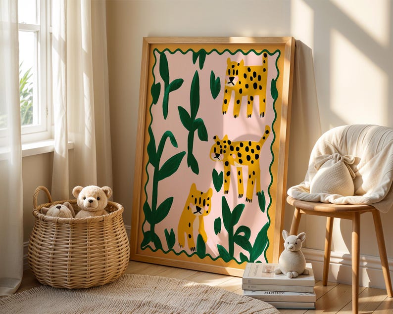 May include: A framed print with a pink background and green leaves. Three yellow and black leopards are depicted in the print. The print is hanging on a wall in a room with a wicker basket and stuffed animals.