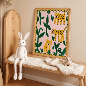 May include: A framed illustration of three leopards in a jungle setting. The leopards are yellow with black spots and are surrounded by green leaves and pink flowers. The frame is made of wood and has a gold finish.